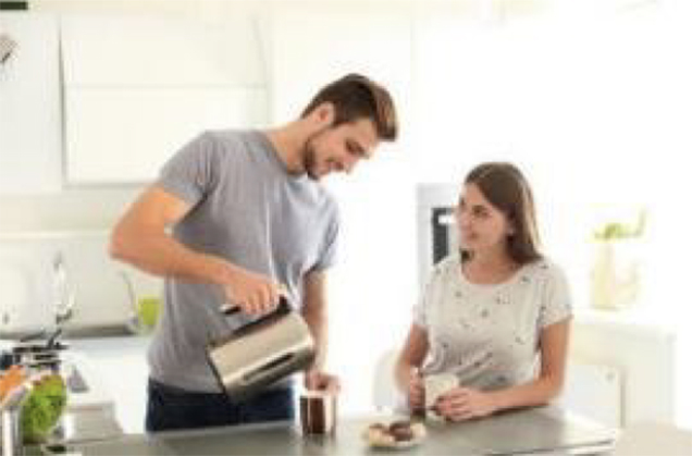 Two people enjoying coffee in a brightly lit kitchen.